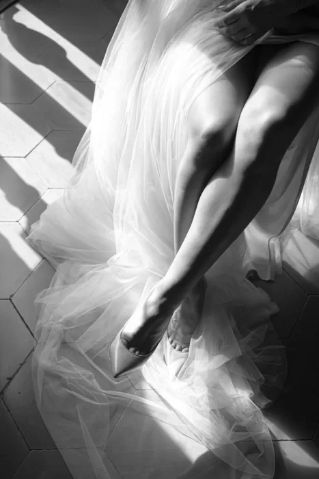 Black and white detail shot of the bride’s tulle gown and heels, highlighting elegant textures and soft light.