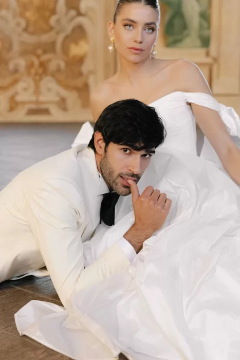 Groom resting against the bride’s gown in Villa Arvedi’s ornate interior.