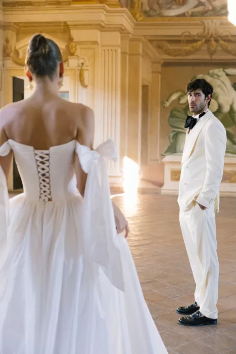 Bride and groom in white formalwear inside the frescoed halls of Villa Arvedi.