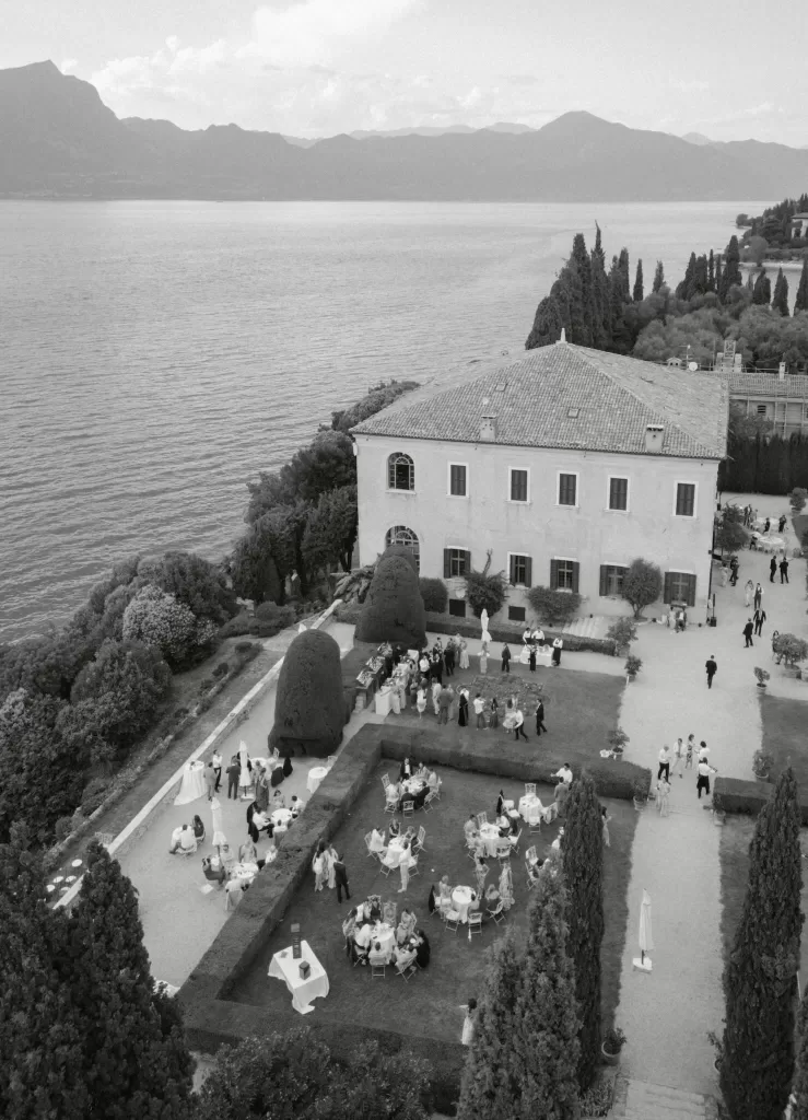 Aerial view of Villa San Vigilio overlooking Lake Garda with guests enjoying the garden wedding reception.