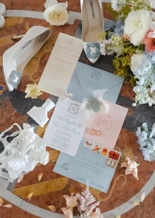Flat lay of Villa San Vigilio wedding details including stationery, shoes, rings, and delicate floral accents.