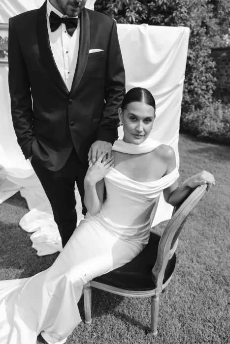 Black and white portrait of the bride seated in a fitted gown beside the groom at Wallalong House.