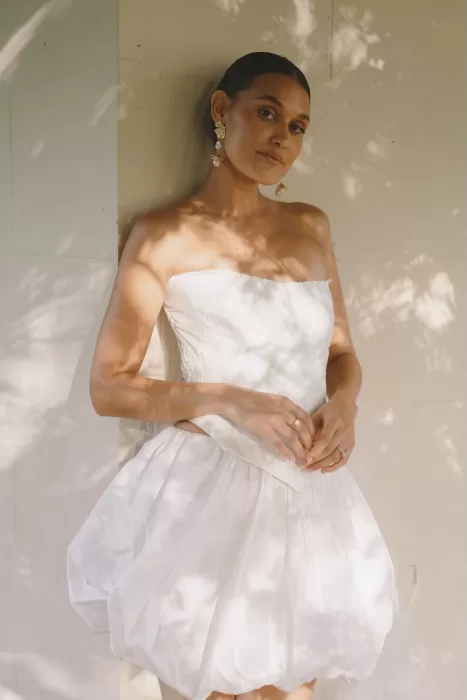 Bride in strapless short wedding dress with statement earrings at Wallalong House.