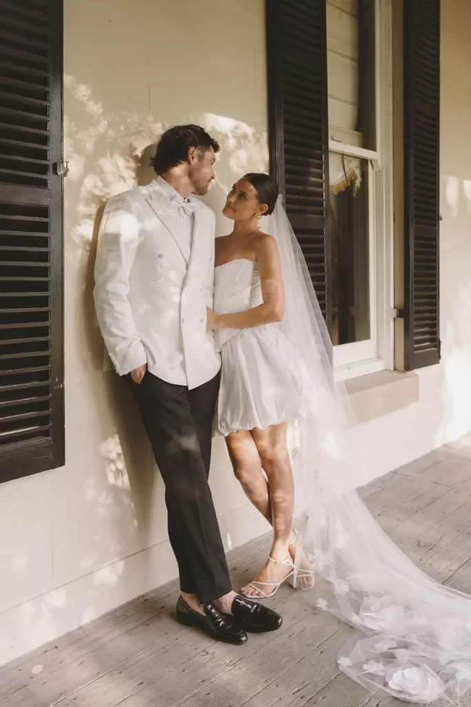 Bride and groom standing together on the veranda at Wallalong House