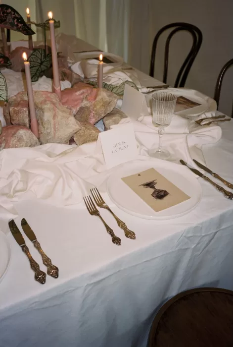 Elegant wedding place setting with vintage cutlery, folded card, and pink stone centerpiece at Wallalong House.