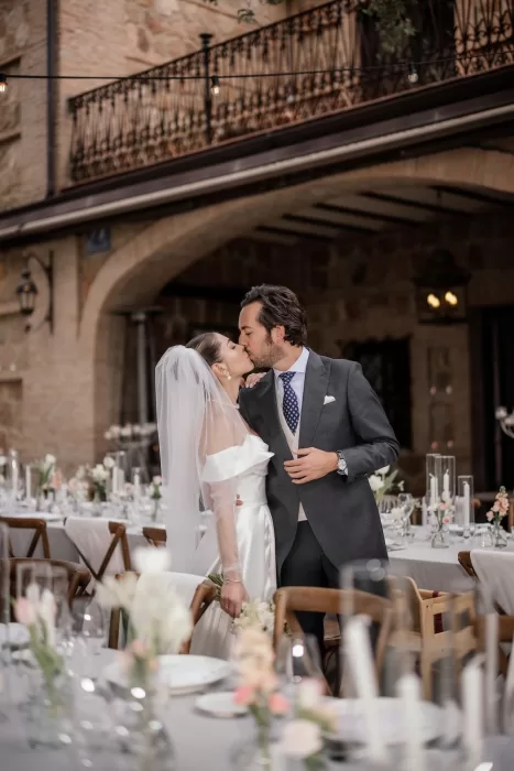 The newlyweds share a kiss at their candlelit dinner setup at Cigarral de la Mercedes.