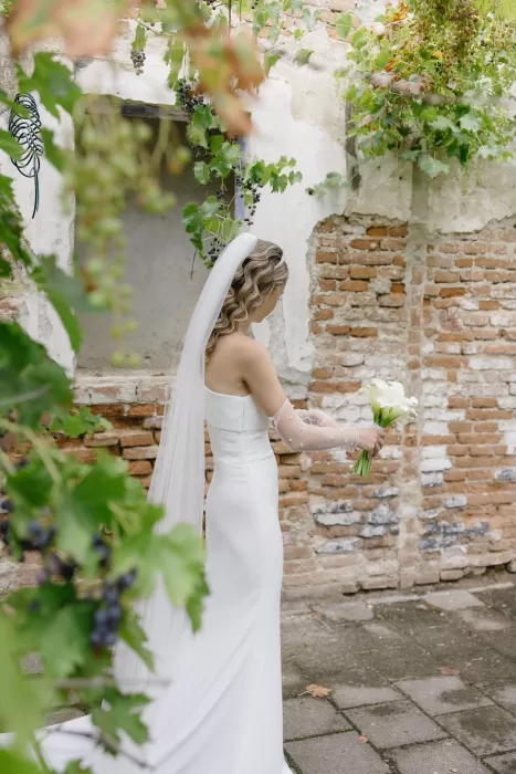 Bride holding calla lilies in the garden courtyard of Winery Hans Igler.