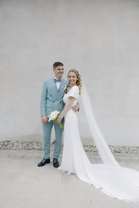 Full-length portrait of bride and groom with flowing veil at Winery Hans Igler.