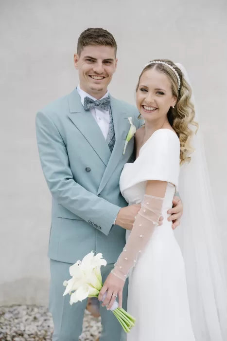 Bride and groom sharing a joyful moment in elegant wedding attire at Winery Hans Igler.