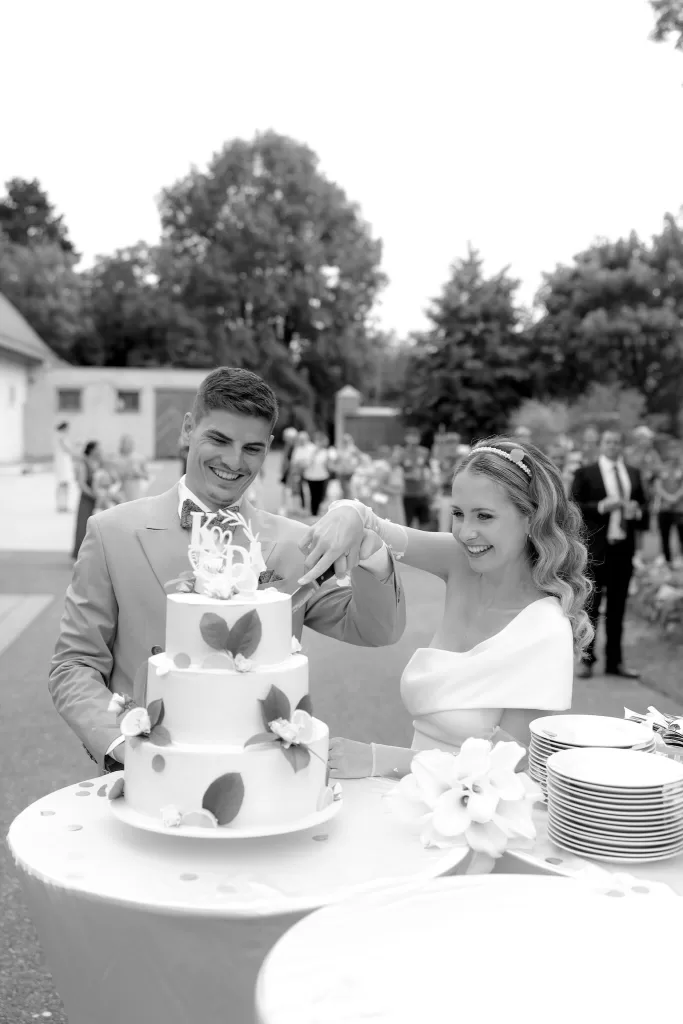 Bride and groom cutting a tiered lemon-decorated wedding cake at Winery Hans Igler.
