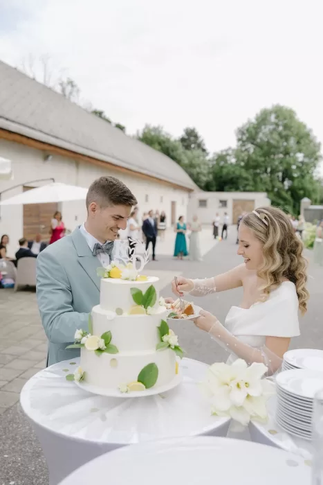 Bride and groom cutting lemon-decorated wedding cake at Winery Hans Igler.