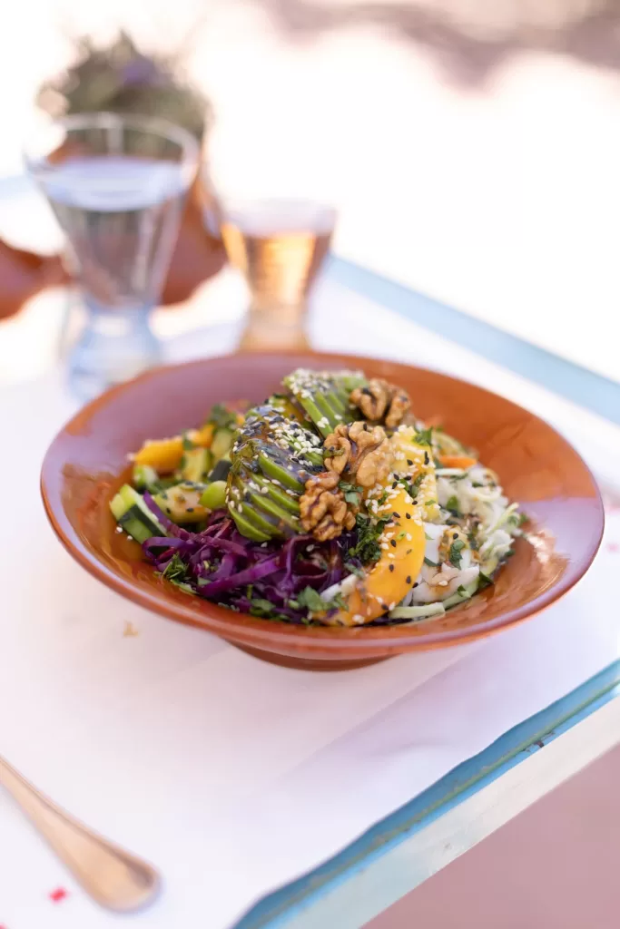Fresh vegetable and walnut salad served in a terracotta bowl at Beldi Country Club.