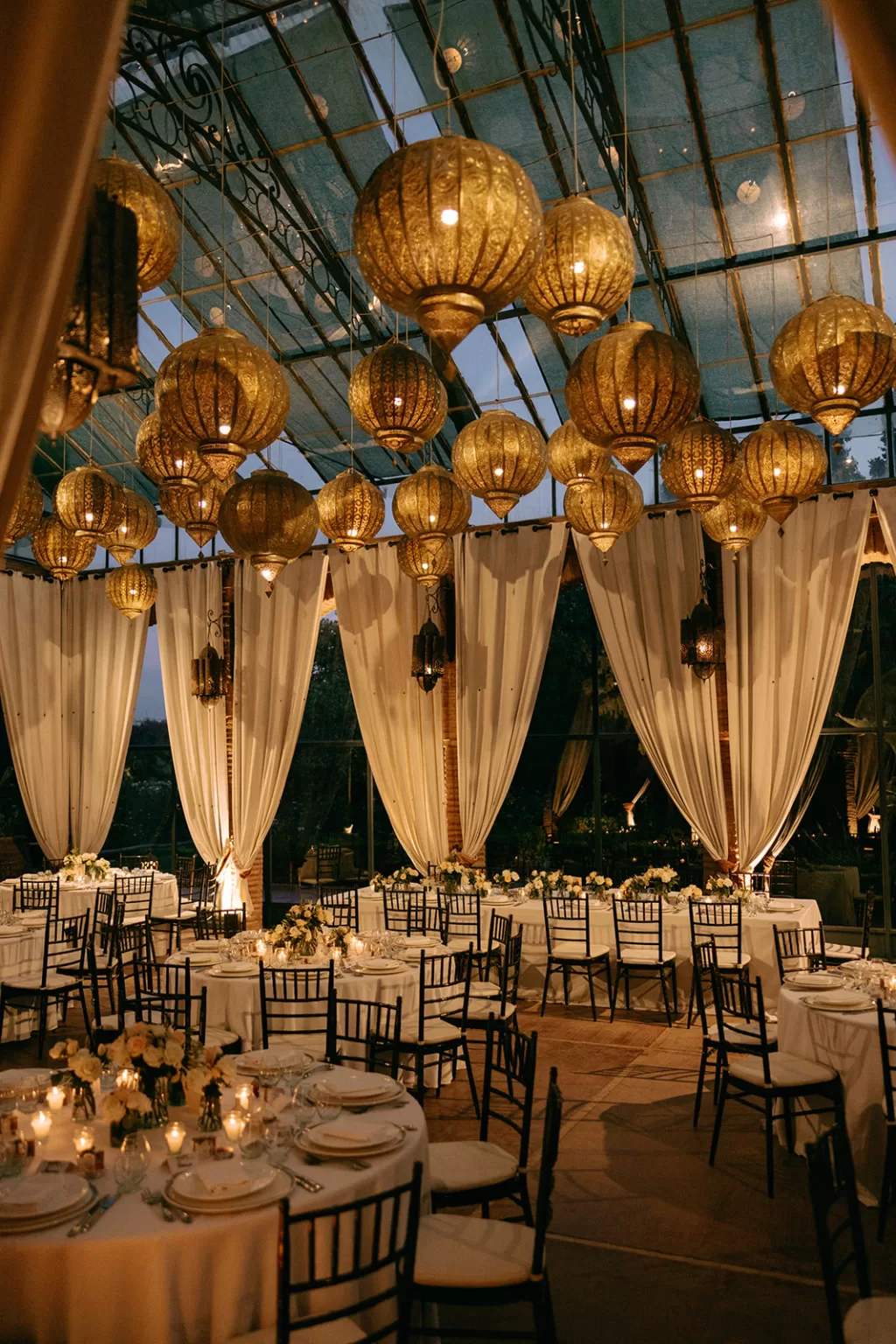 Warmly lit golden lanterns hanging above the reception space at Beldi Country Club, creating an intimate and magical atmosphere.