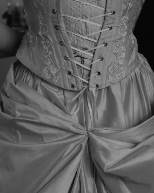 Close-up of embroidered corset and gathered fabric on a wedding gown.