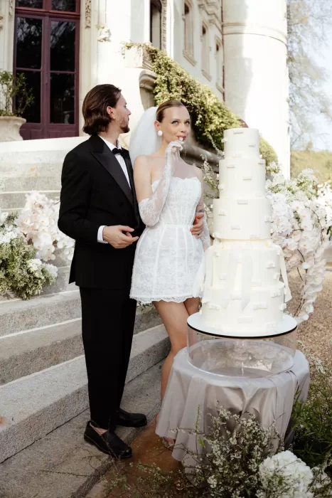 Bride and groom enjoying their wedding cake moment on the steps of Chateau Challain.