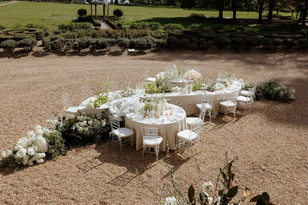 Elegant outdoor wedding reception setup with white florals and round tables at Chateau Challain.