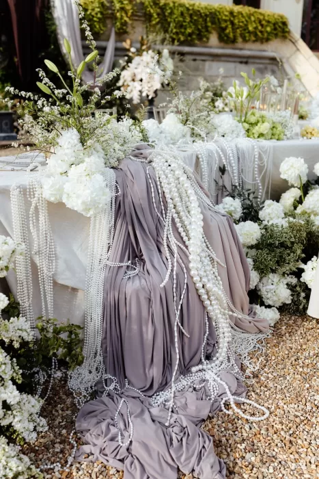 Elegant wedding table detail with cascading pearls and white floral arrangements at Chateau Challain.