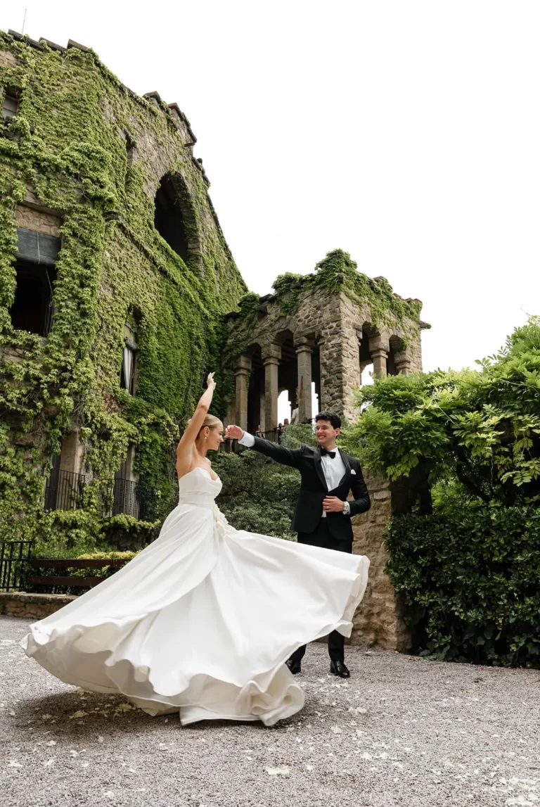 Newlyweds dance in front of ivy-covered castle walls, captured by Domrose Photography.