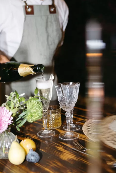 Champagne being poured into vintage glasses during a wedding dinner at Finca Son Collell