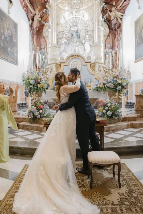 Bride and groom sharing a kiss at the altar of a historic church near Finca Son Collell
