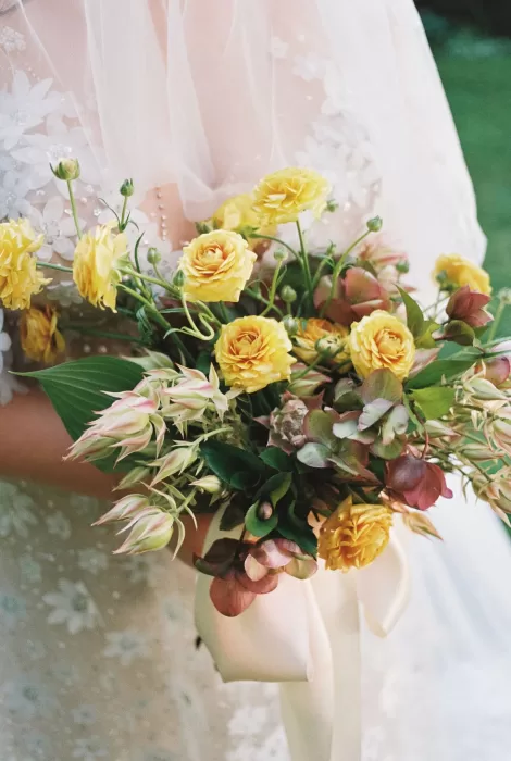 Close-up of a yellow rose bridal bouquet with soft greenery and delicate pink details at House Boheme.