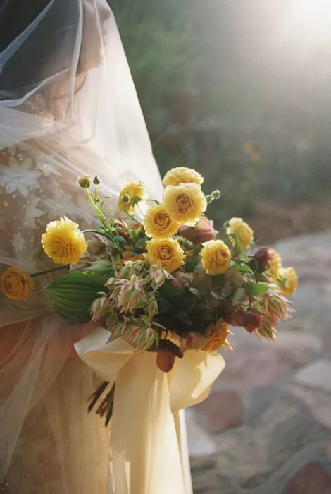 Romantic bouquet of yellow roses and blush florals glowing in soft evening light at House Boheme.