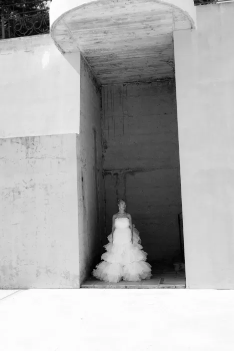 Bride in a tiered gown posing against striking architectural walls at La Finka 4.1.