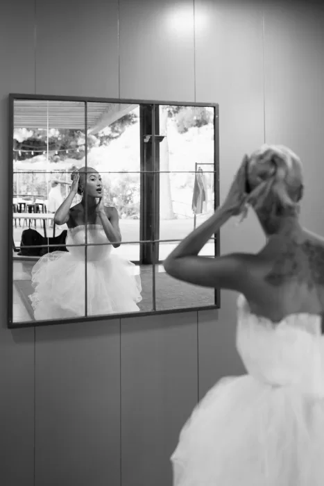 Bride adjusting her hair in front of a large mirror before the ceremony at La Finka 4.1.