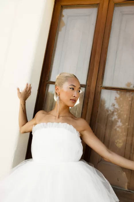 Bride in a strapless gown posing gracefully by wooden doors at La Finka 4.1.