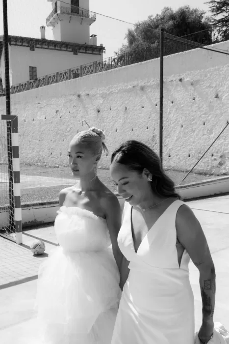 Brides walking hand in hand in the sunlit courtyard of La Finka 4.1.