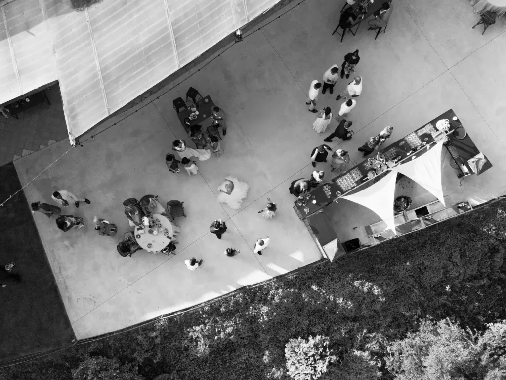 Black-and-white aerial view of wedding guests mingling outdoors at La Finka 4.1.