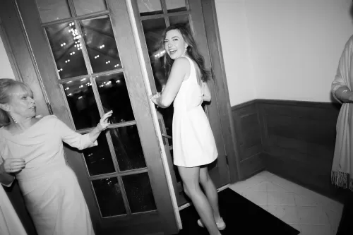 Bride laughing in a short white reception dress with bow detail at Laguna Gloria.
