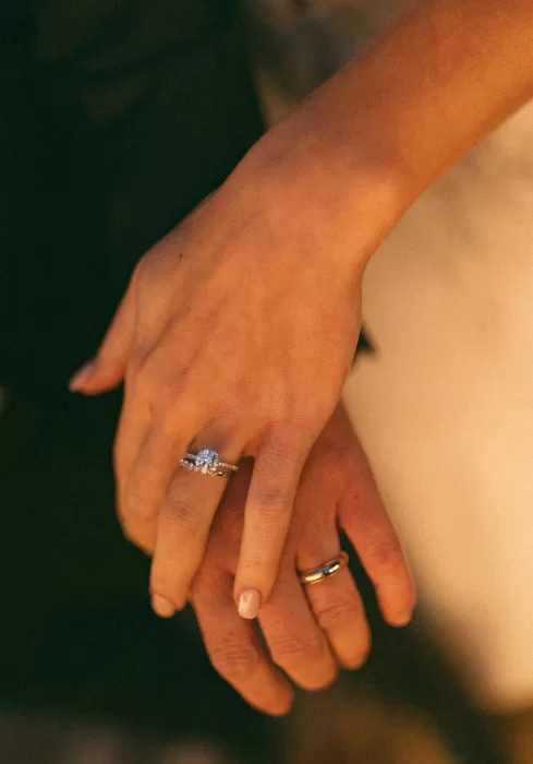 Close-up of bride and groom’s hands with wedding rings at Laguna Gloria.