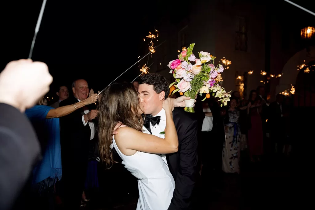 Bride and groom kissing during a sparkler exit at Laguna Gloria.