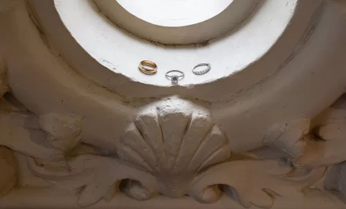 Wedding rings displayed on a carved stone detail at Laguna Gloria.
