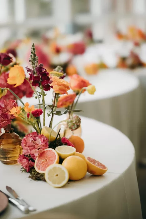 Close-up of citrus and colorful floral centerpiece adding freshness to Masia Aldamar reception tables.