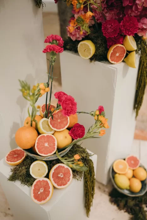 Fresh citrus fruits and bright flowers arranged as colorful wedding ceremony decor at Masia Aldamar.