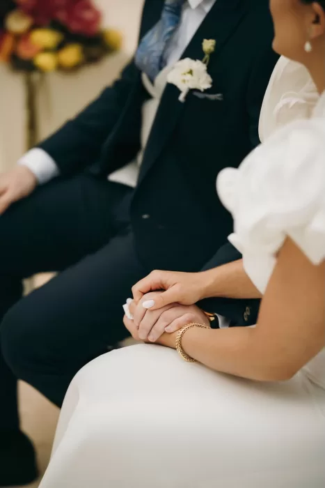 Intimate moment as bride and groom hold hands during their wedding ceremony at Masia Aldamar.