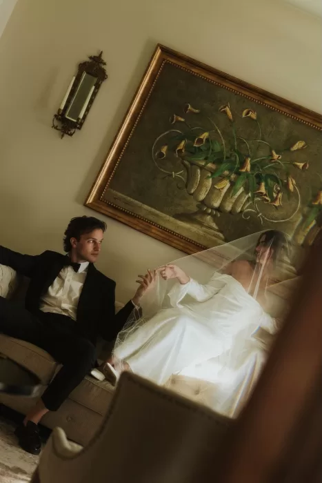 Bride and groom sharing a quiet moment on a sofa at Stone Haven, with soft light creating an intimate atmosphere.