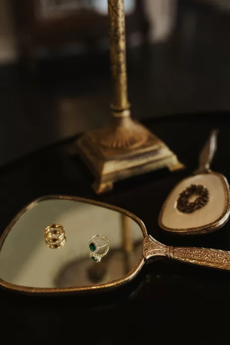 Elegant wedding rings displayed on a vintage mirror tray at Stone Haven