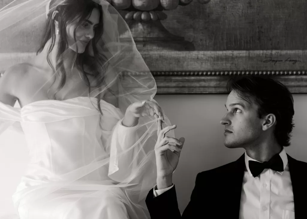 Bride under her veil holding hands with the groom in an elegant portrait at Stone Haven.