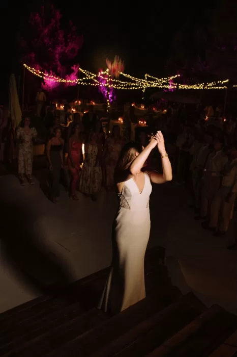 Bride tossing bouquet under twinkling string lights during reception at Villa Blue Star Ibiza.