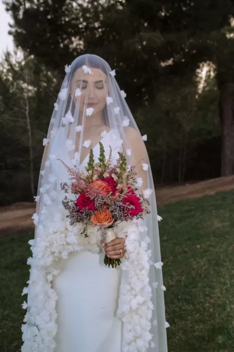 Bride in floral veil holding a bright bouquet at Villa Blue Star Ibiza.