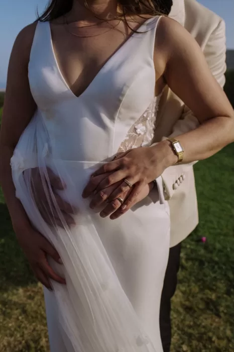 Close-up of couple’s hands resting on bridal gown with rings and gold watch at Villa Blue Star Ibiza.