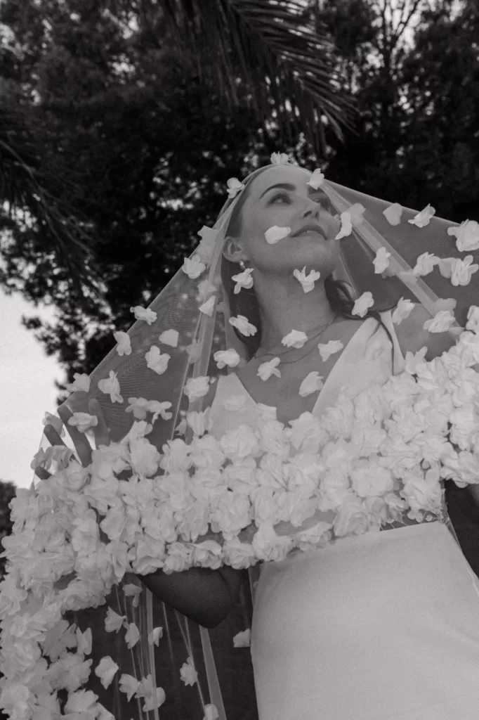 Bride in a flower-adorned veil gazing upward in the gardens of Villa Blue Star Ibiza.