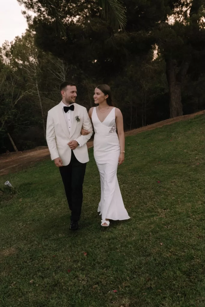 Bride and groom strolling arm in arm across the gardens of Villa Blue Star Ibiza.