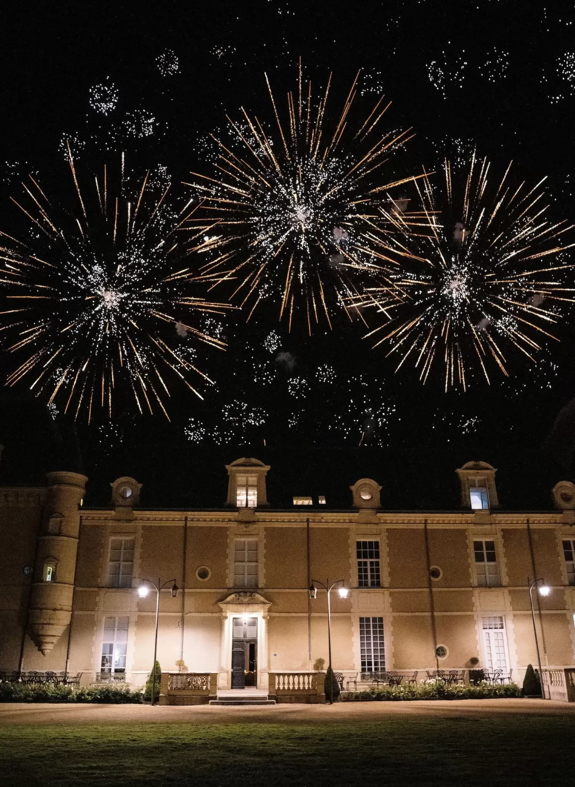 Spectacular fireworks lighting up the night sky above Château de Jalesnes during a wedding celebration.