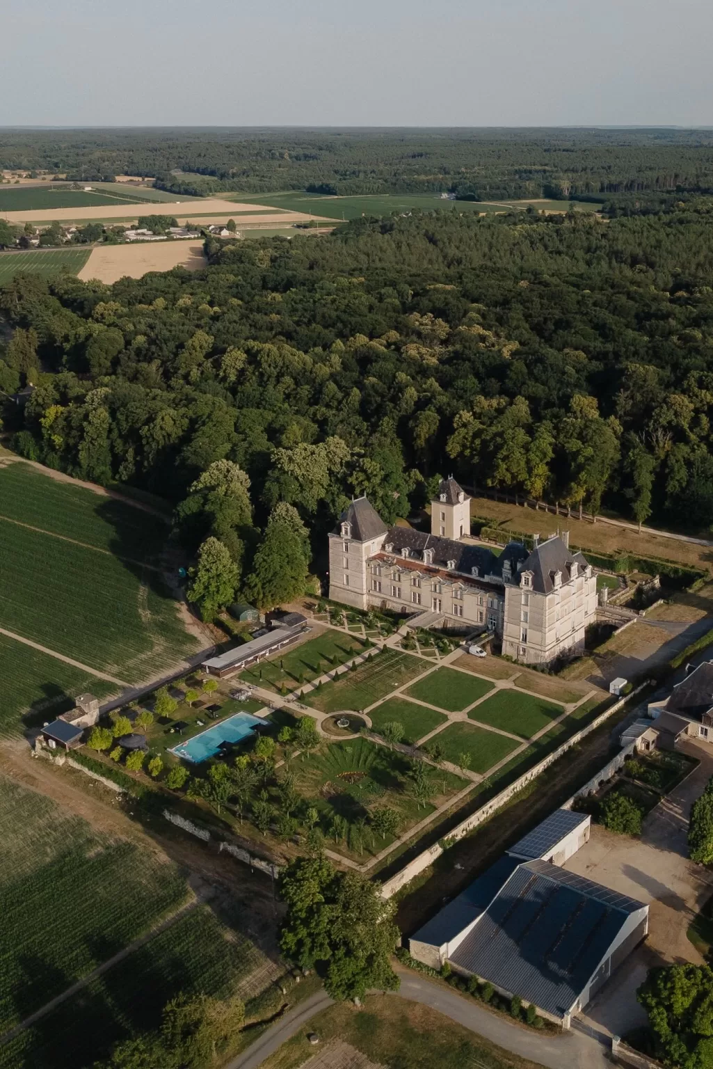 Aerial shot of Château de Jalesnes and its formal gardens surrounded by vineyards and countryside views.