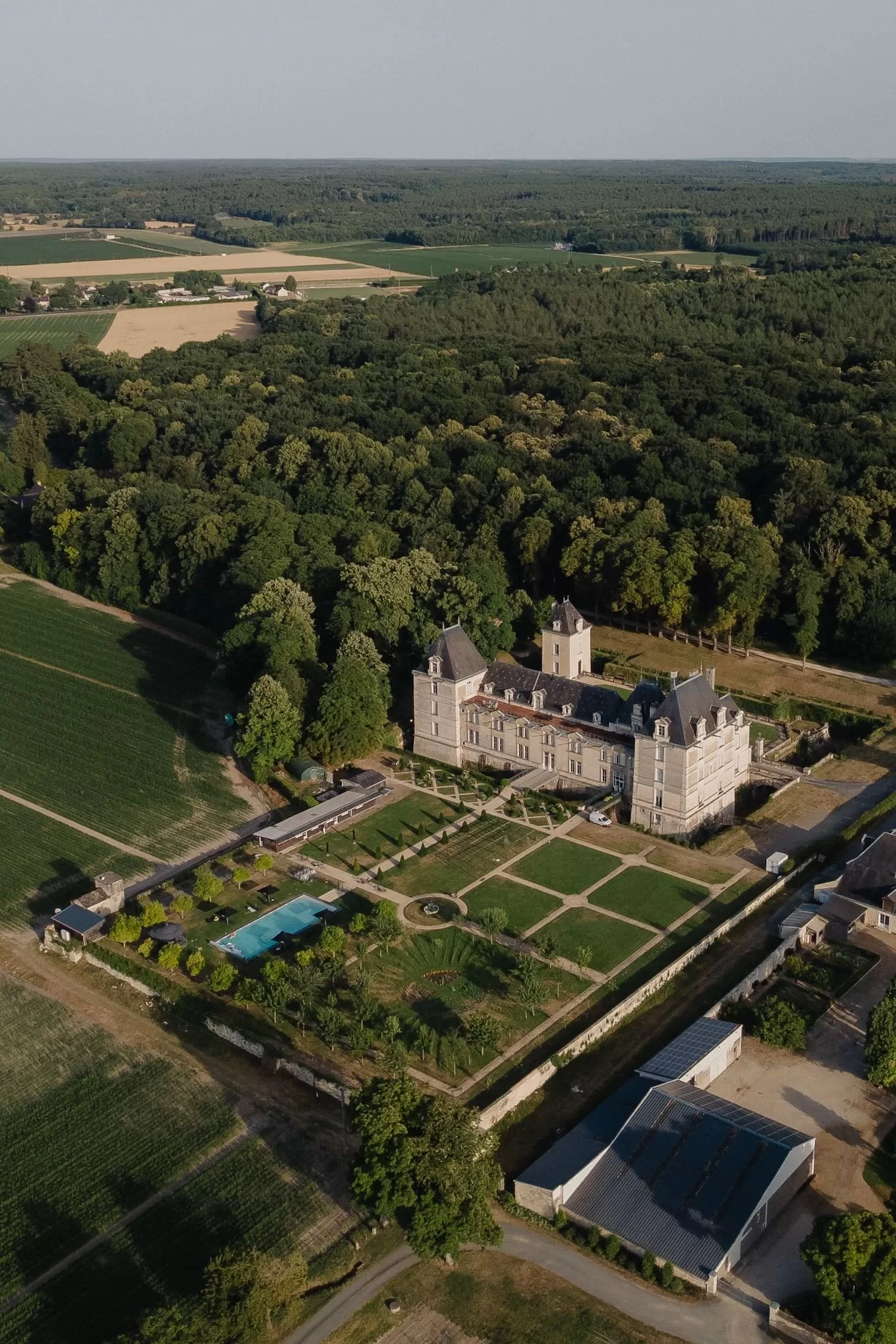 Aerial shot of Château de Jalesnes and its formal gardens surrounded by vineyards and countryside views.