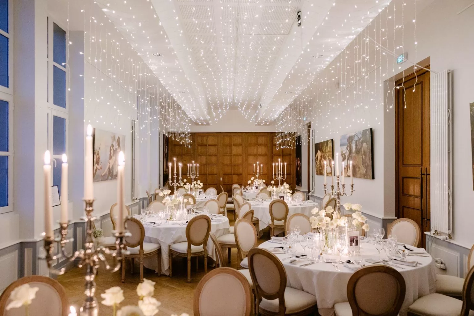 Candlelit reception dinner at Château de Jalesnes beneath twinkling fairy lights.